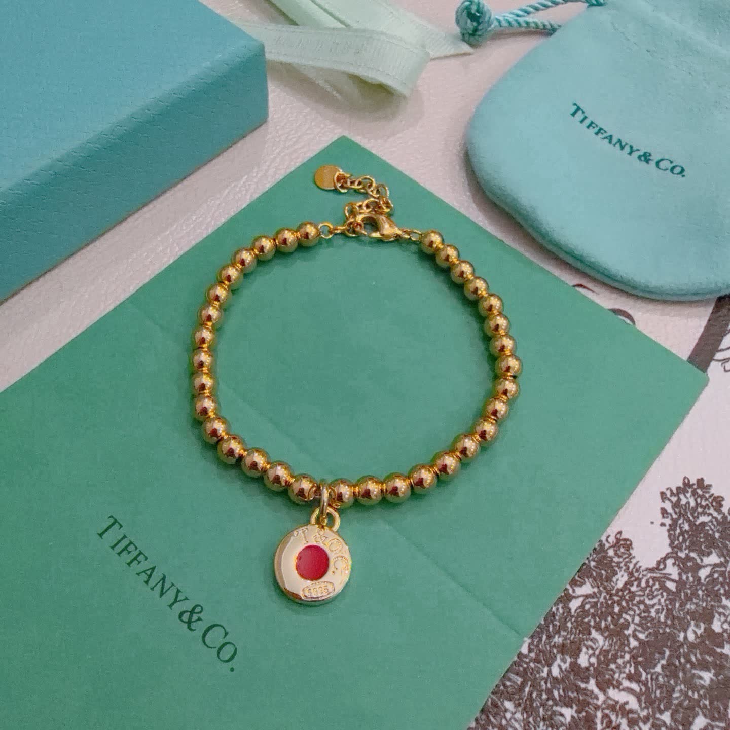 Tiffany & Co. Gold Bead Bracelet with Red Enamel Charm